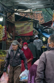 A bustling street market scene in Banten, Indonesia with people shopping for fresh produce.
