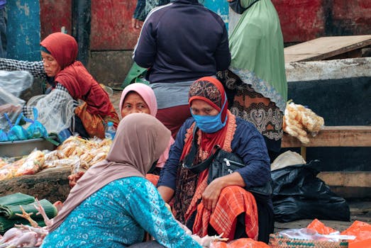 Elderly women at a traditional market in Banten, Indonesia, engaging in conversation and trade.