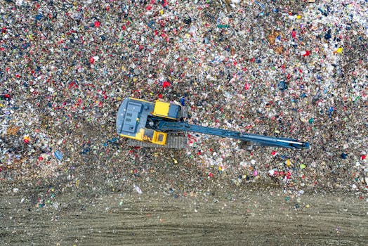 Aerial shot of an excavator working at a large waste disposal site in Banten, Indonesia.