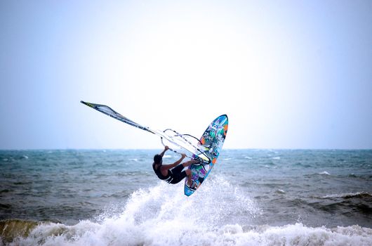 Capture the thrill of kite surfing on waves against a bright blue sky.