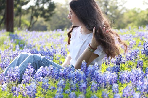 Young Woman Sitting on a Field with Bluebonnets