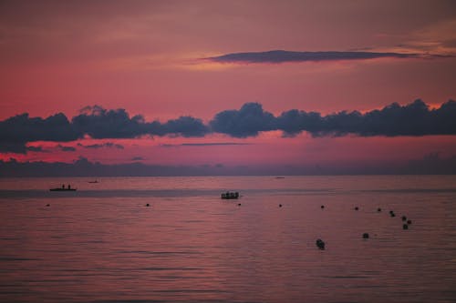 Night sea with boats under sky at sunset
