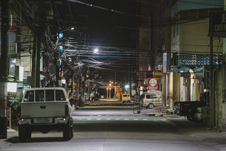 Old Pickup On Empty Road In City At Night