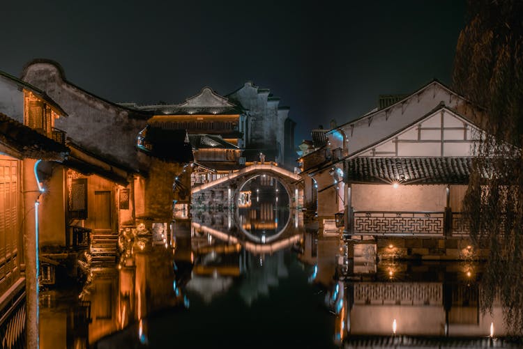 Old Buildings Reflecting In Pond At Night