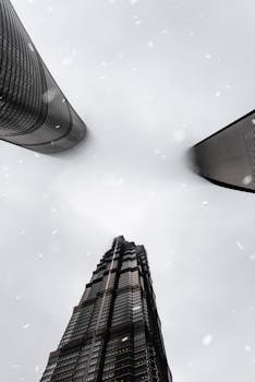 A dramatic view of Shanghai skyscrapers disappearing into the fog, captured from below.