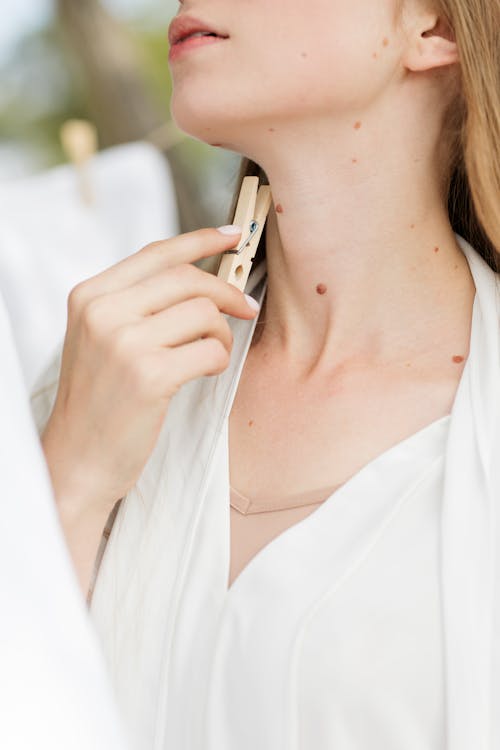 Woman in White Top Holding a Clothespin