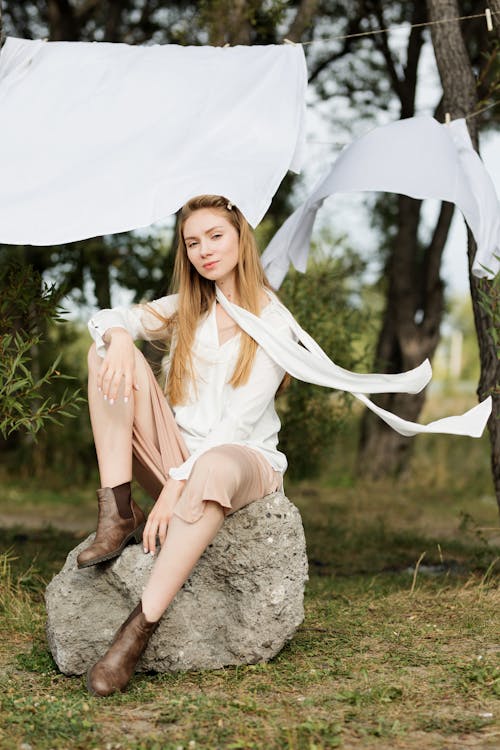 Woman in White Long Sleeve Shirt Sitting on Rock · Free Stock Photo