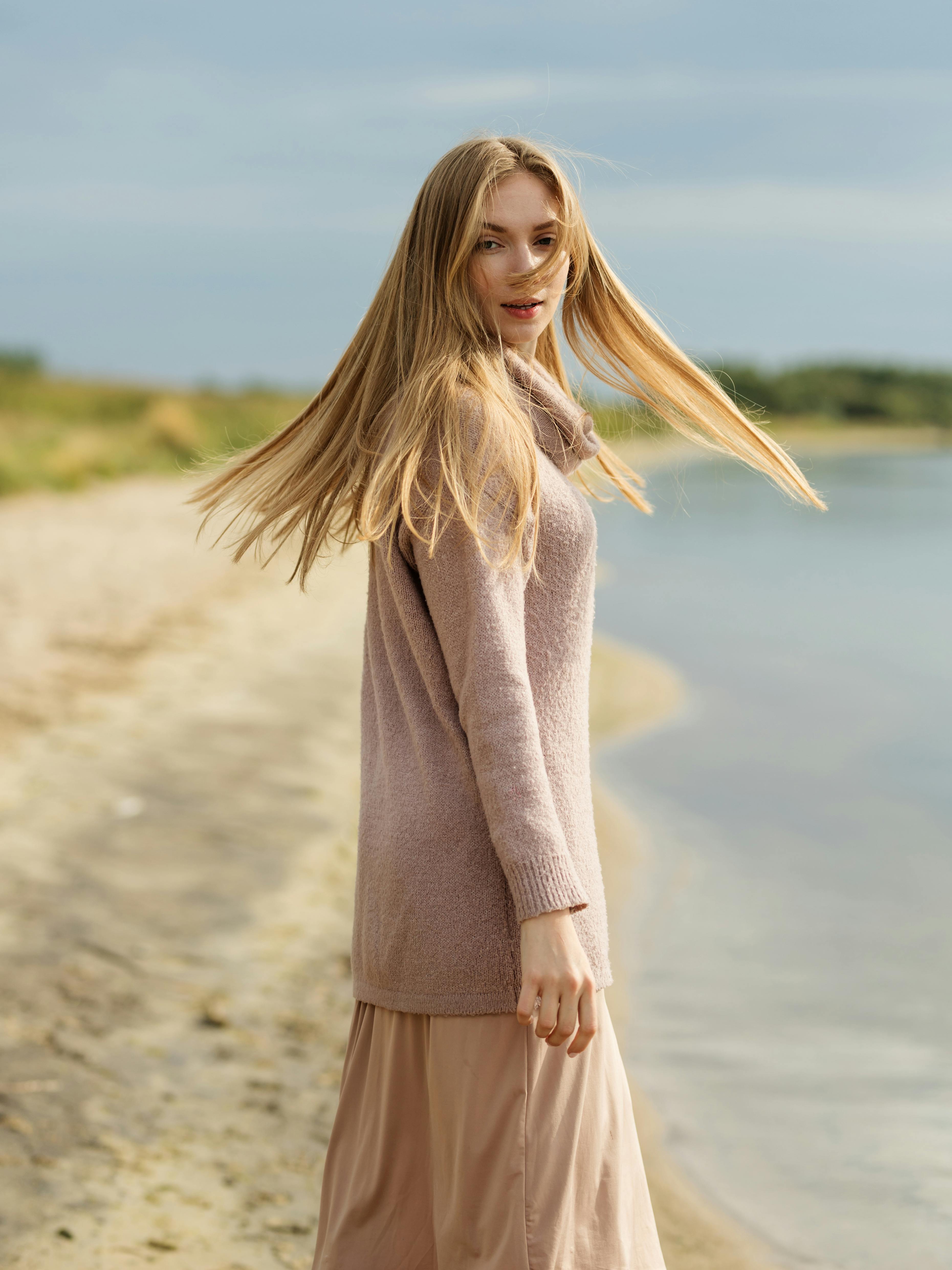 一位年轻的金发女子在沙滩上享受微风轻拂的宁静一天