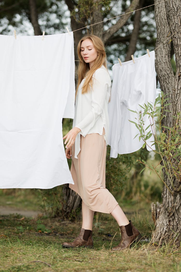 Woman Standing Near Hanging White Clothings