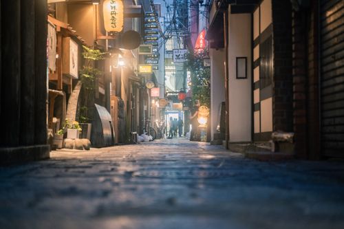 Free Explore a narrow, illuminated alley at night in Osaka, Japan, showcasing traditional lanterns and shop signs. Stock Photo