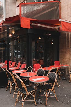 Cozy Paris cafe with red awning and wicker chairs, capturing classic street ambiance.