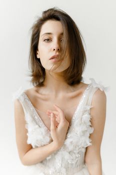 一位年轻女子身穿白色花卉连衣裙，肖像特写展现优雅