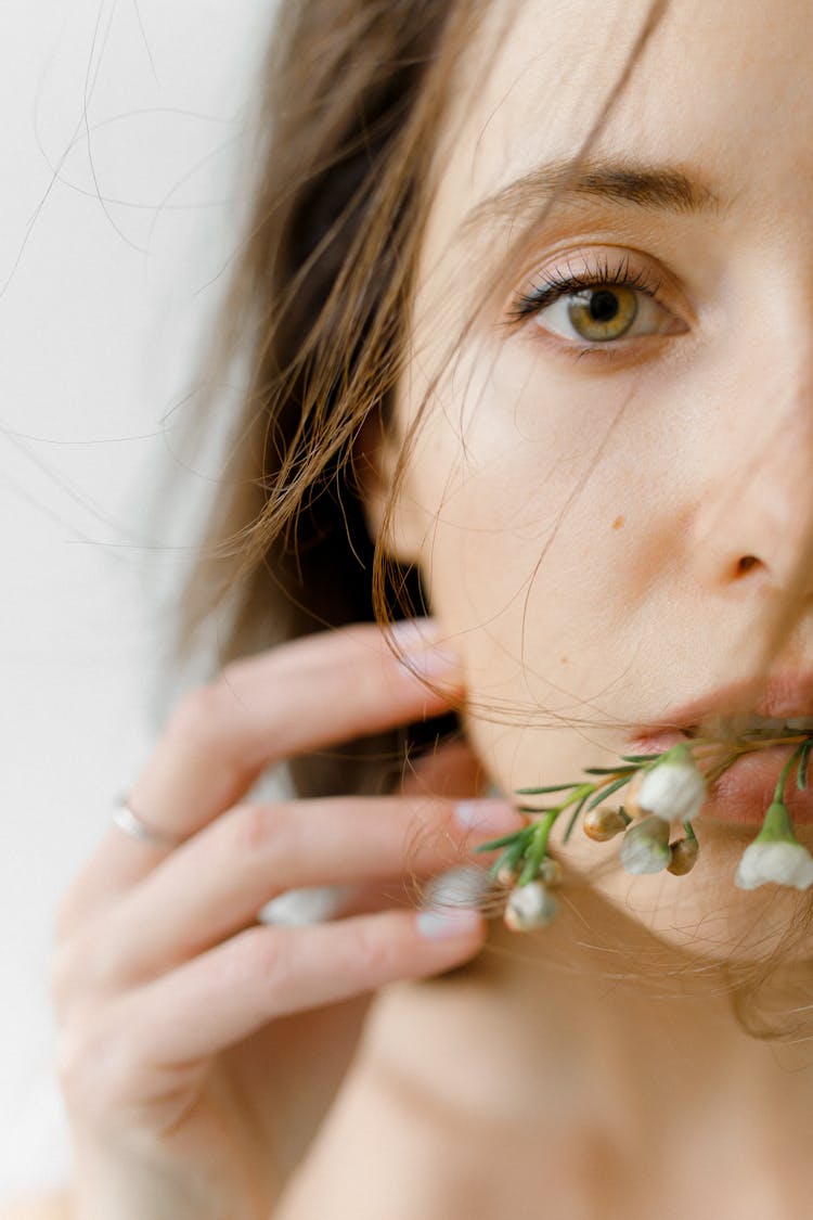 Woman Holding A Stem Of Flowers