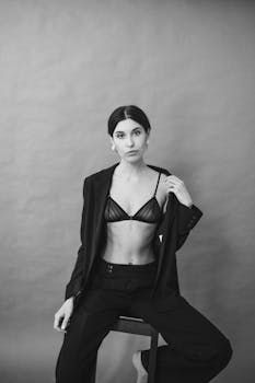 这幅黑白肖像时尚地描绘了一位在工作室环境中摆姿的女性