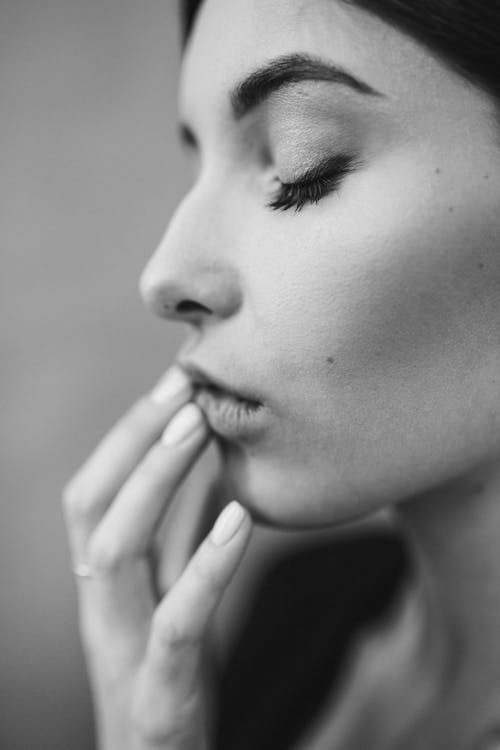 Grayscale Photo of a Woman With Her Hand on  Mouth