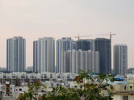 这张印度海得拉巴的现代摩天大楼全景图，展现了城市发展与建筑起重机的景象