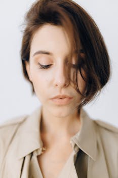 Natural light portrait of a woman with short brunette hair and subtle makeup.