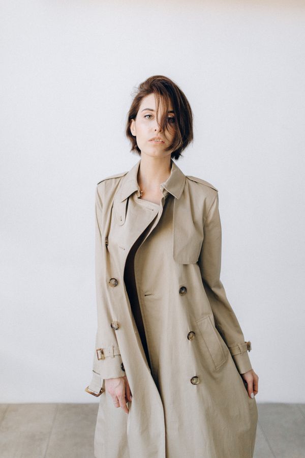 Woman in a trench coat in a studio-style portrait
