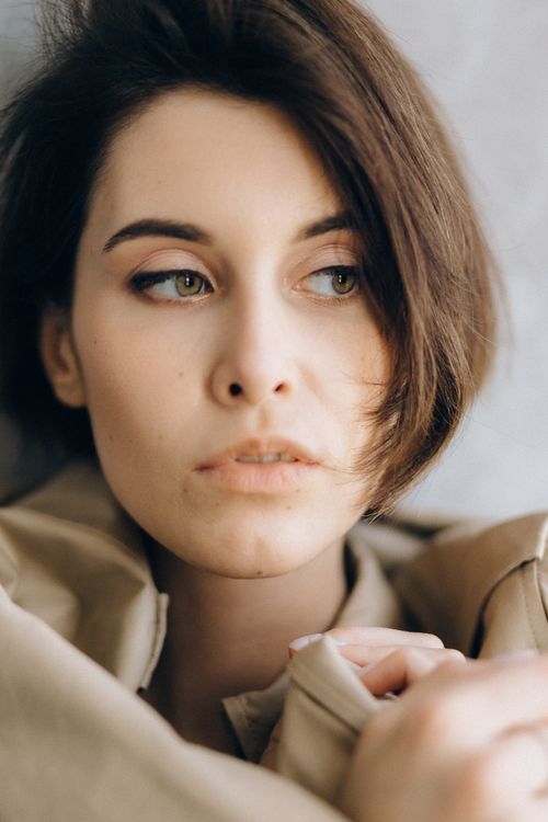 Free Close-up portrait of a woman with short hair looking away thoughtfully, showcasing natural beauty. Stock Photo