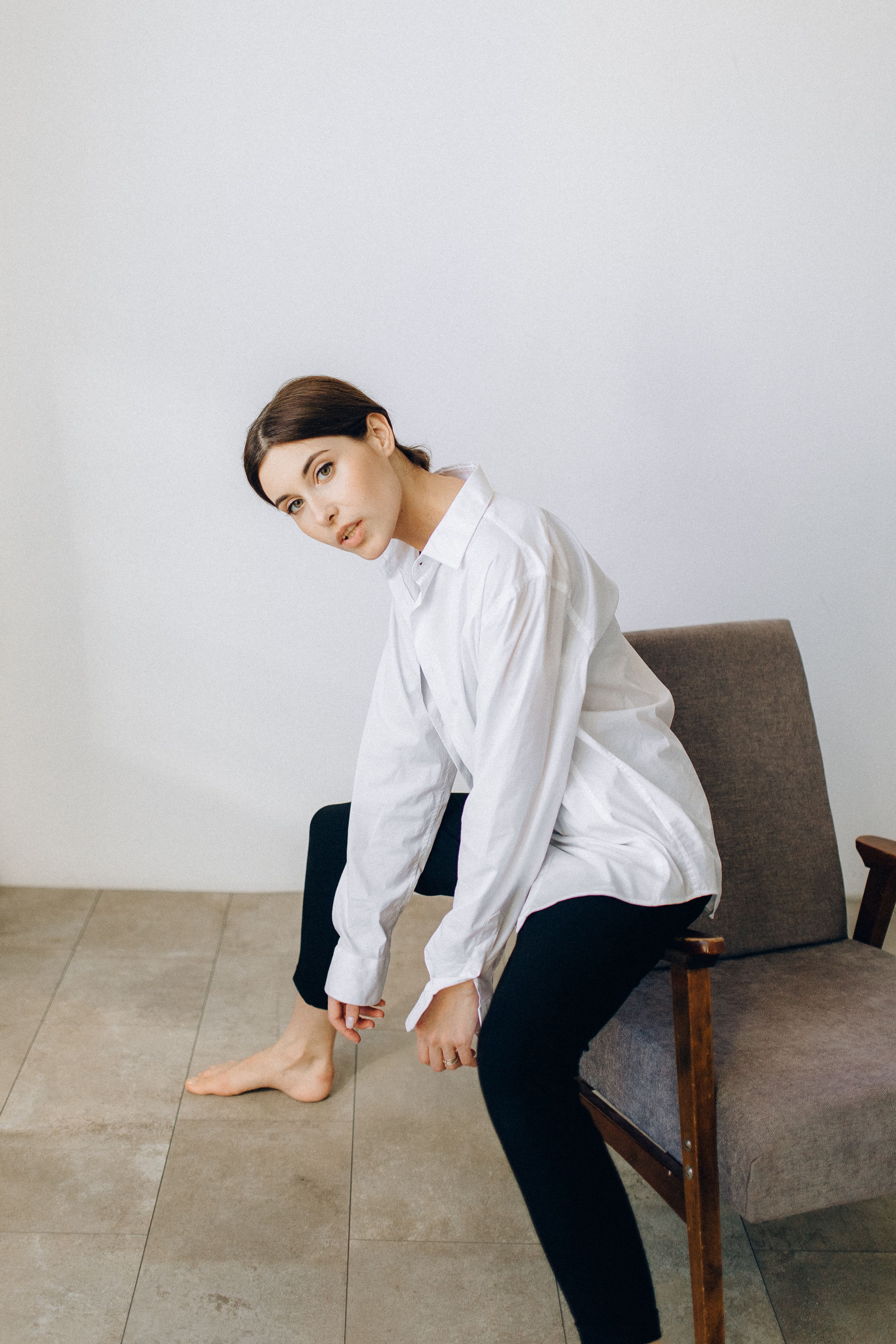 Woman in White Long Sleeve Shirt Sitting on a Chair · Free Stock Photo