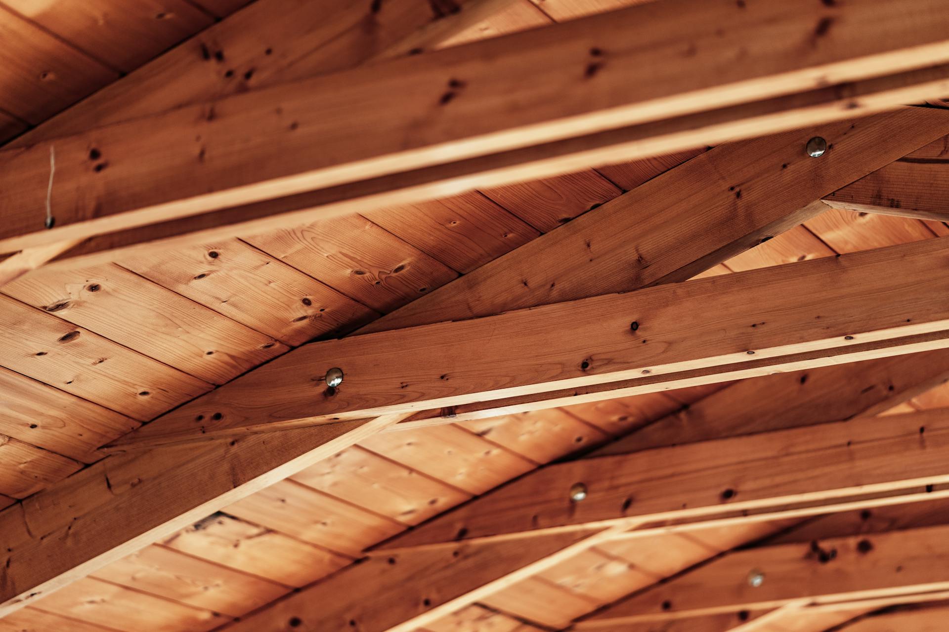 Close-up of a rustic wooden ceiling with exposed beams and natural wood texture.