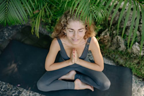 Woman Sitting on Yoga Mat While Meditating