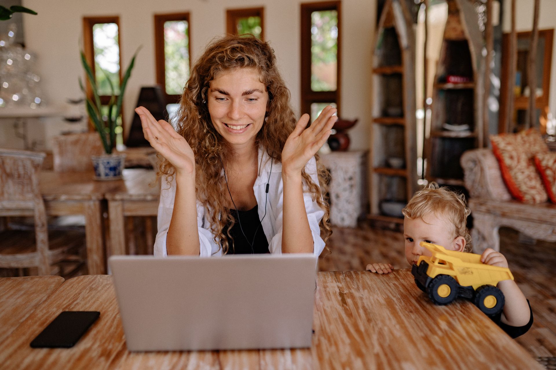 A mother and her child enjoy a video call together on a laptop in a cozy home setting.
