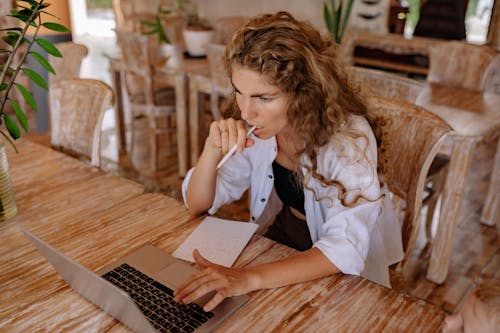 Gratis stockfoto met balpen, computer, gekruld haar