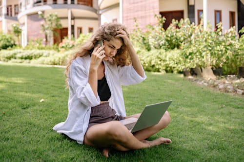 Photo of Woman Using Smartphone and Laptop
