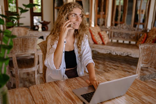 Free Photo of Woman Using Smartphone While Smiling Stock Photo