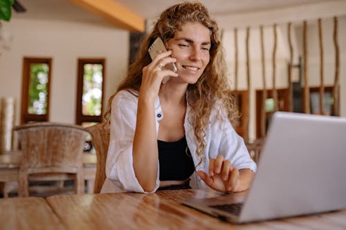 Photo of Woman Using Cellphone While Smiling