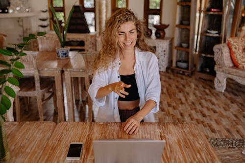 Photo of Woman Smiling While Looking at Silver Laptop