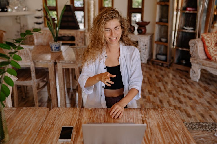 Photo Of Woman Smiling While Looking At Silver Laptop