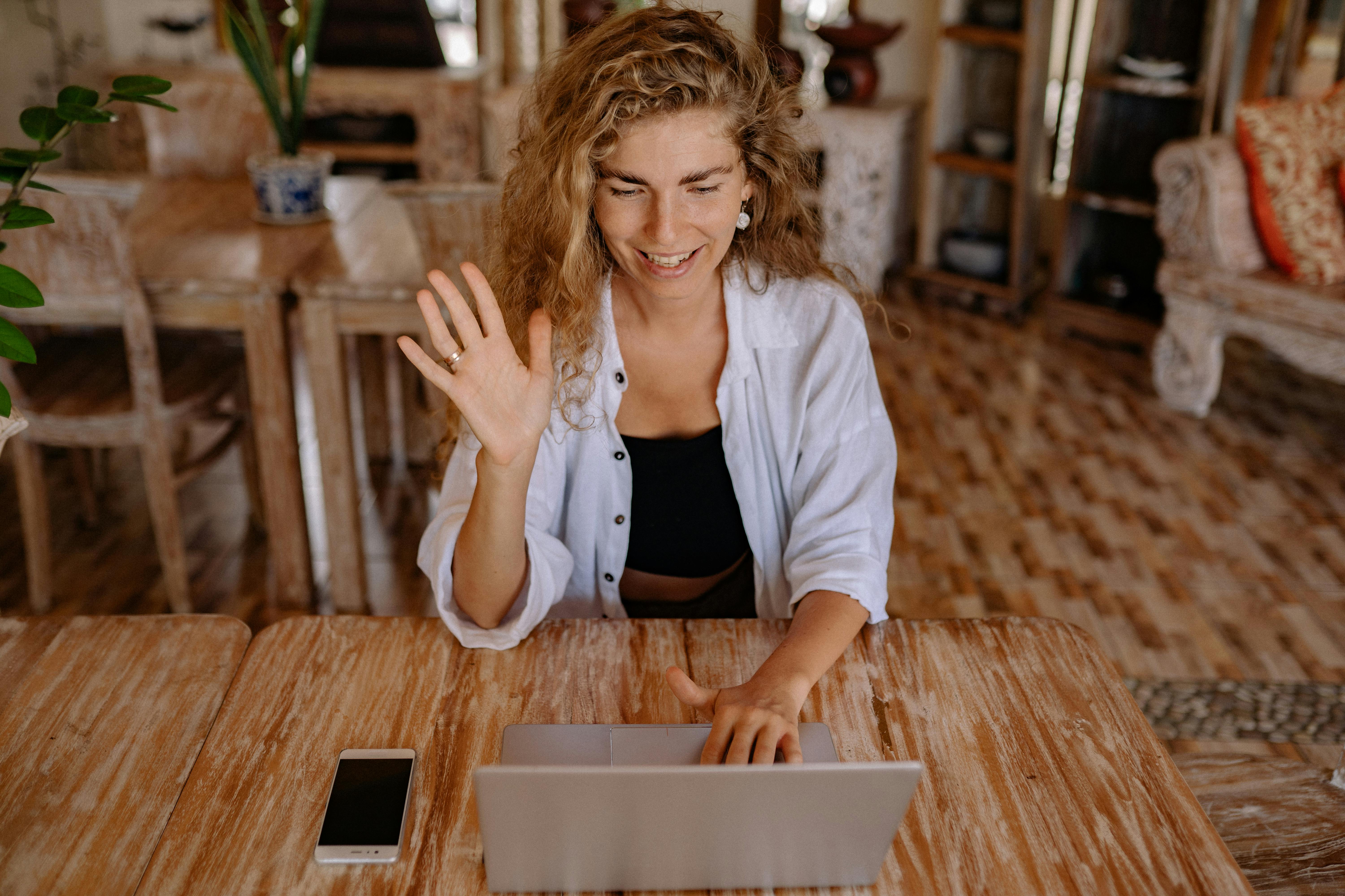 photo of woman saying hi through laptop