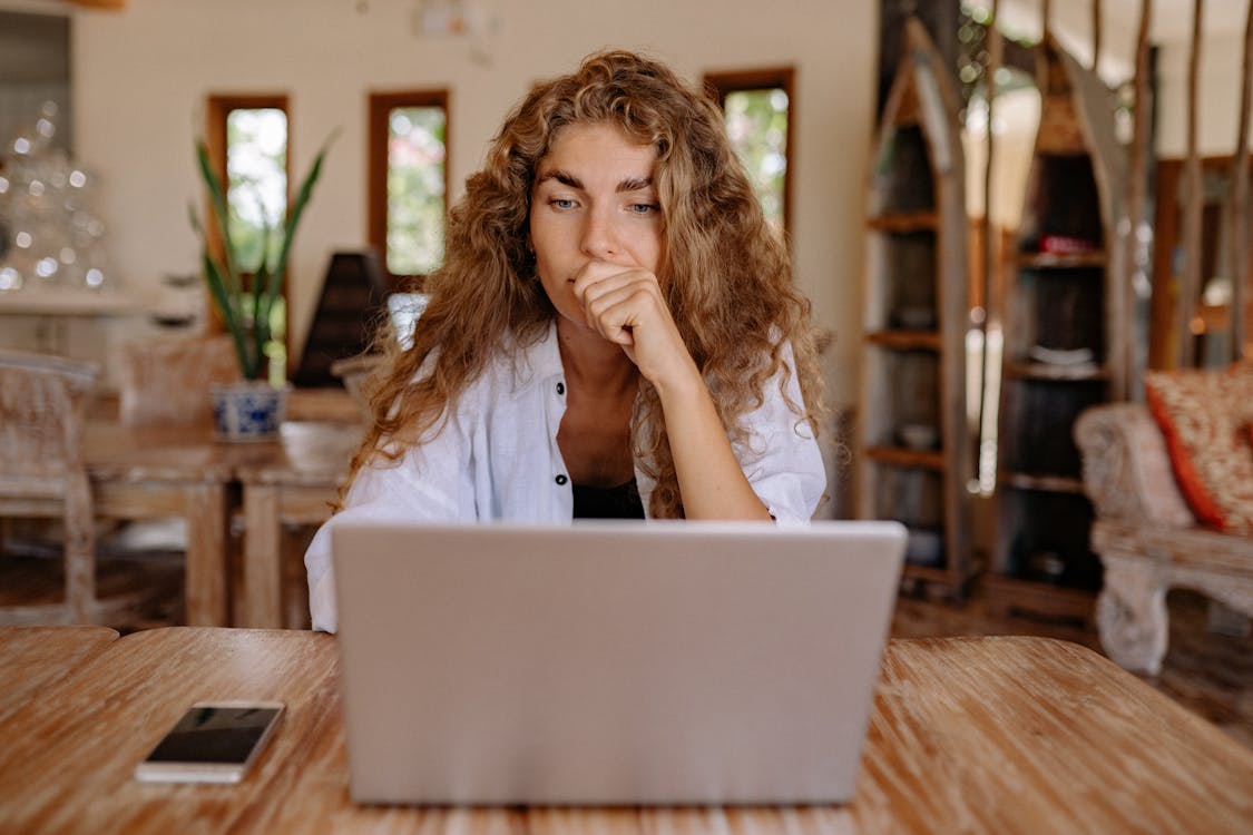 Free Woman in White Button Up Shirt While Using Laptop Stock Photo