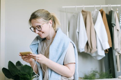 Free Woman Using Smartphone While Smiling Stock Photo