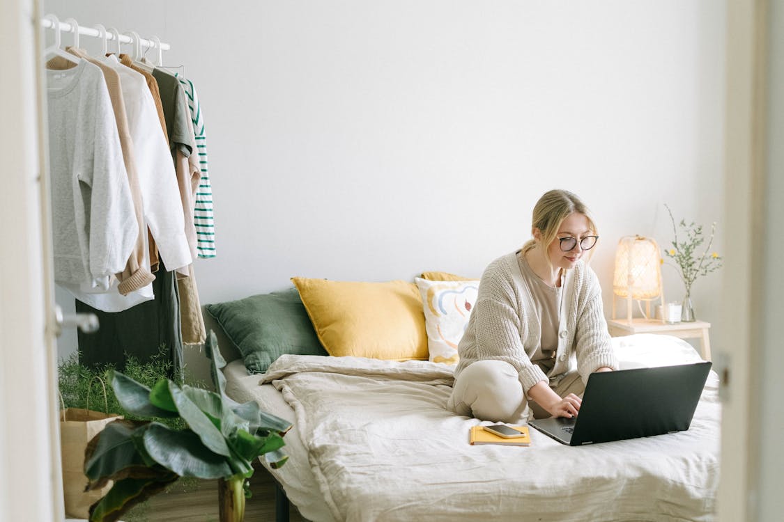 Free Woman in White Sweater Sitting on White Couch Stock Photo