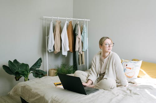 Free Woman in White Sweater Sitting on Bed Stock Photo