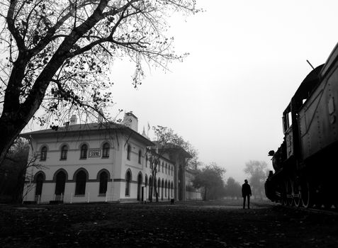 Grayscale Photo of Man and Woman Walking on Street Near Building