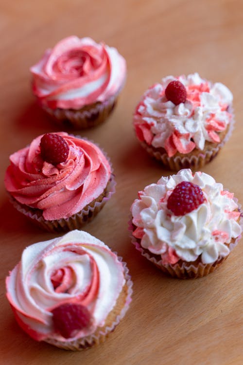 Free Pink and White Cupcake on Brown Wooden Table Stock Photo