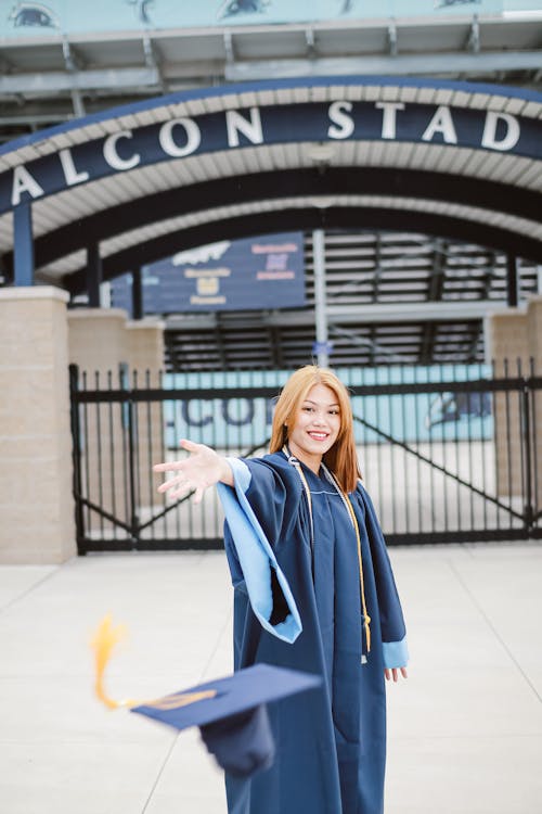 Cheerful Asian young woman graduating from university