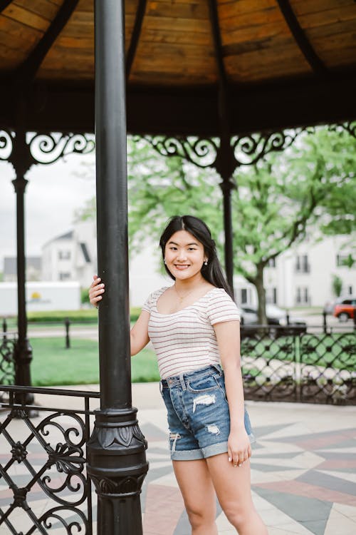 Cheerful Asian woman standing in park terrace