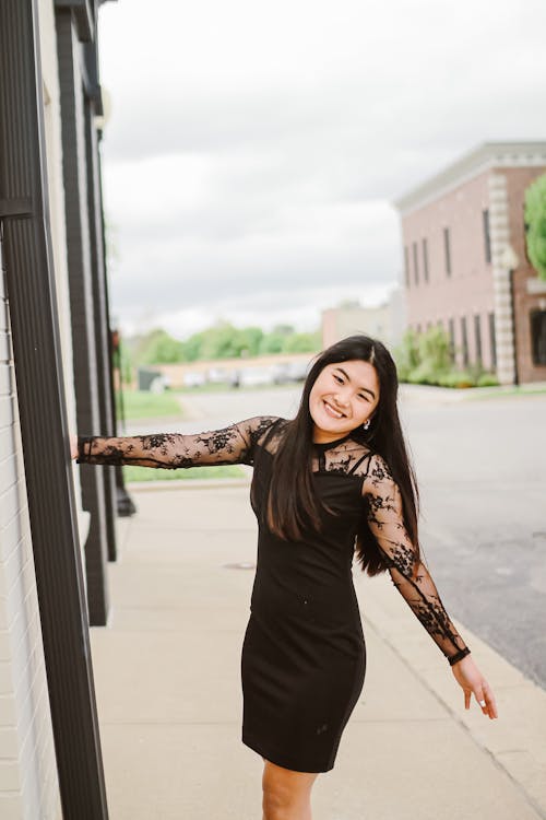 Joyful Asian woman on paved sidewalk