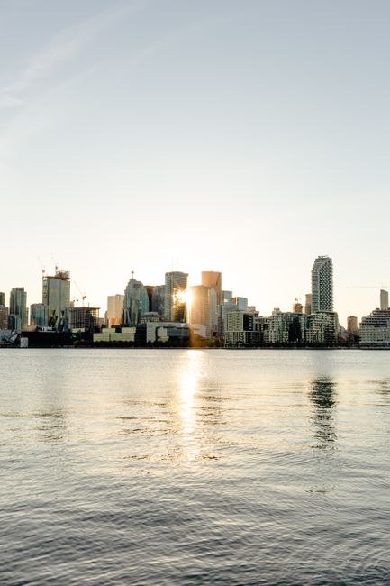 Amazing view of cityscape with contemporary skyscrapers located on calm sea shore beneath clear blue sky