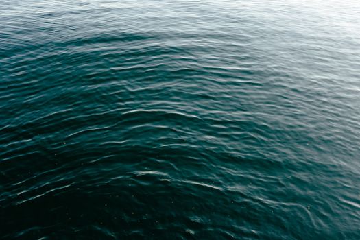 Peaceful ocean surface with gentle ripples and a turquoise hue, capturing a tranquil moment.