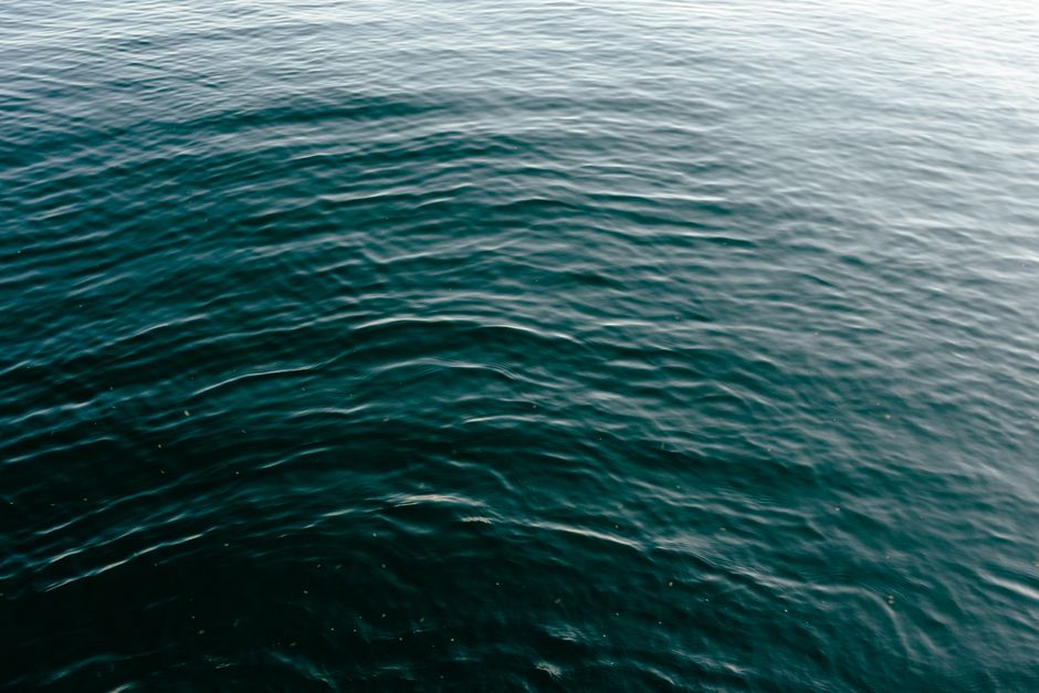 Peaceful ocean surface with gentle ripples and a turquoise hue, capturing a tranquil moment.