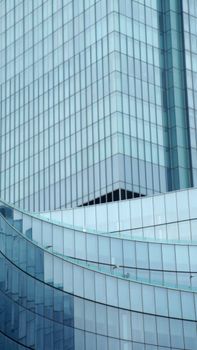 Corner of contemporary glass building reflecting blue sky and located in metropolis center on clear day