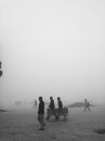 Faceless people walking on pavement in dense fog