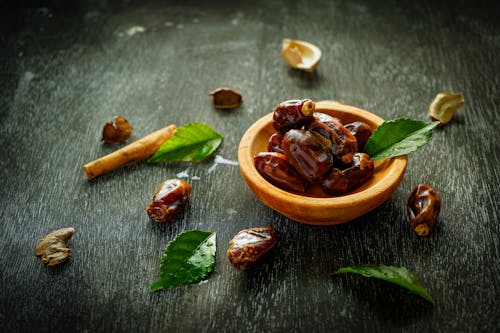 Free Bowl with sweet dates on black table Stock Photo