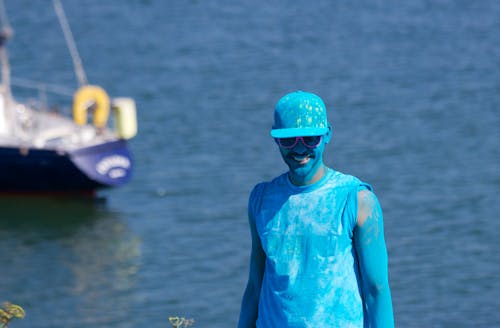 Free Man Covered With Blue Paint Near Body of Water Stock Photo